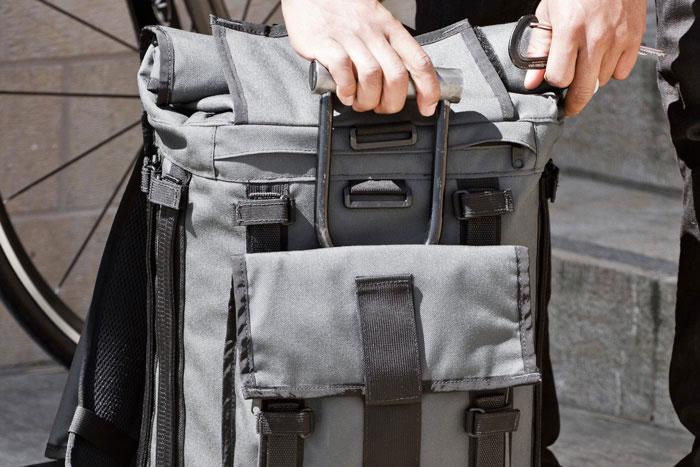 Front view of a person hand opening a Mission Workshop R6 Arkiv Field Pack.