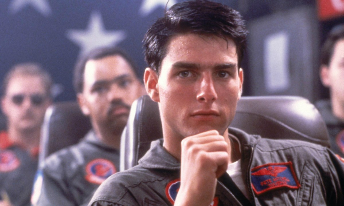 Tom Cruise sits in a chair in Top Gun.