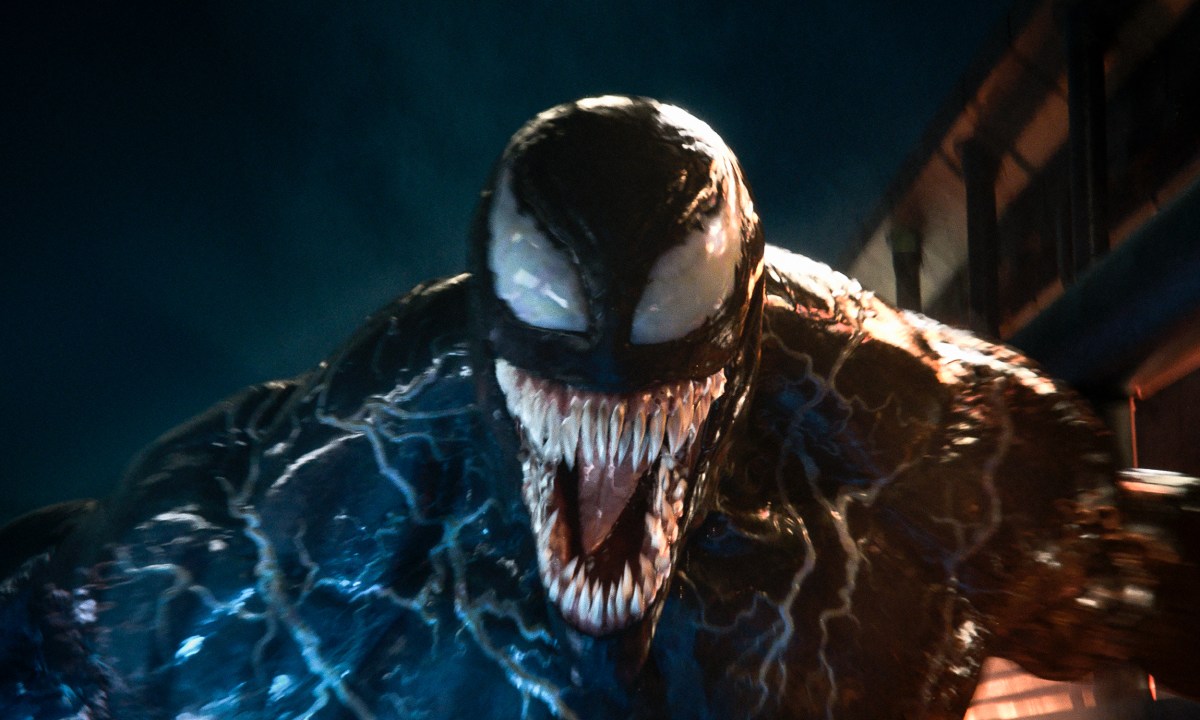 Venom looks at the camera with his mouth open.
