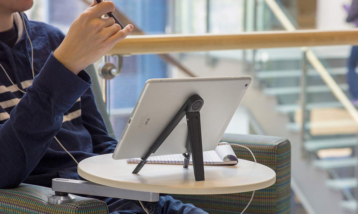 Man using iPad at a table with an iPad stand.