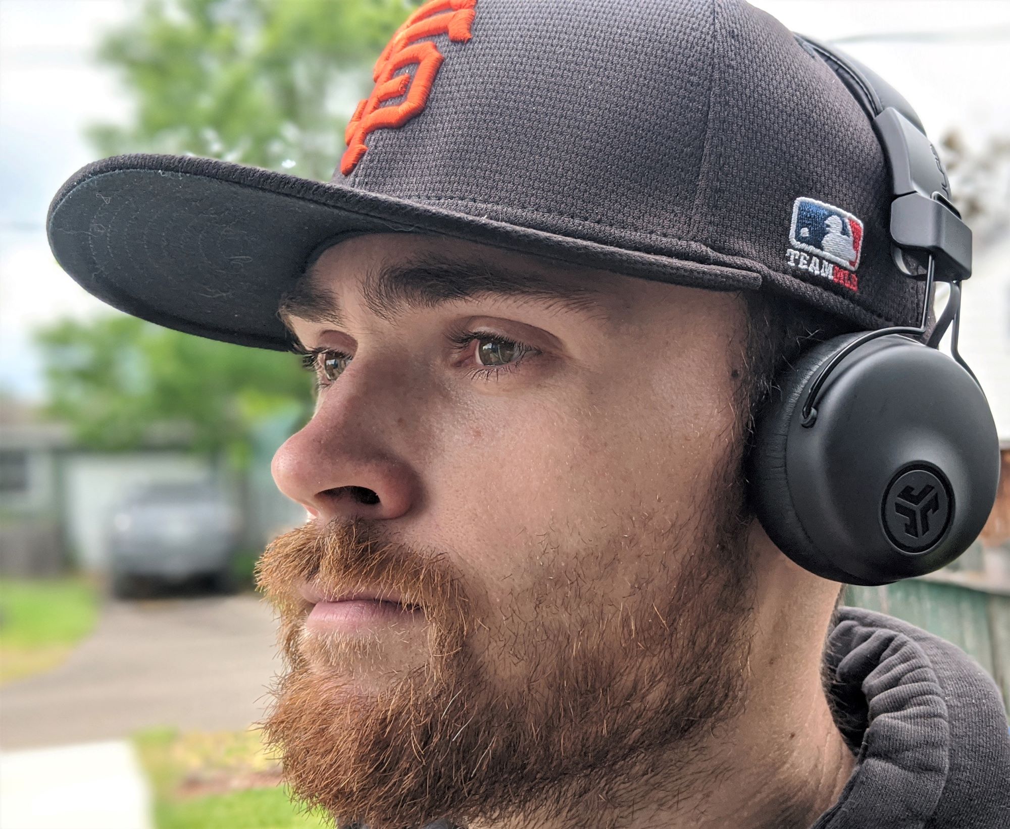 A man wears the JLab Studio ANC over a hat.