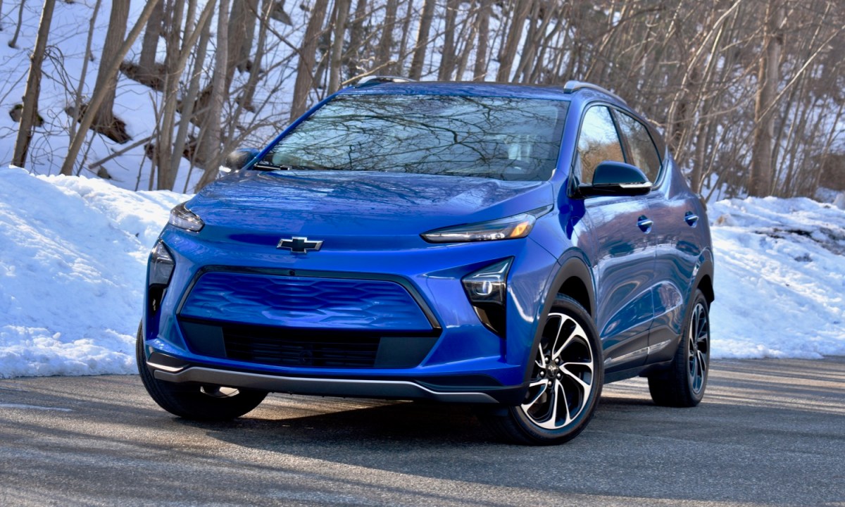 A blue Chevy Bolt against a snowy backdrop.