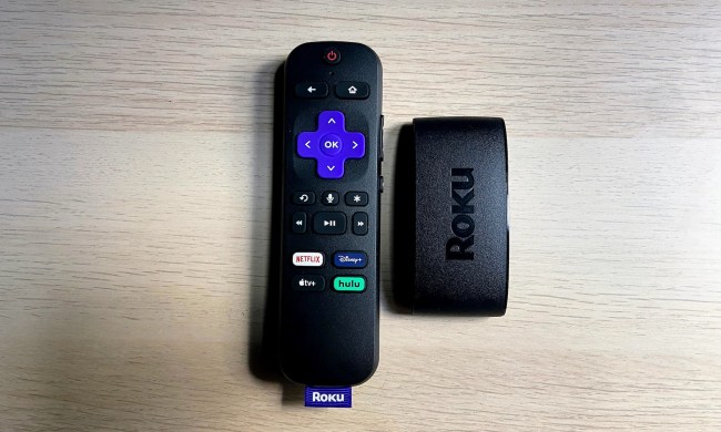 The Roku Express 4K Plus with remote on a wooden surface.