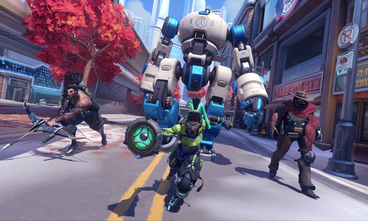 A team of Overwatch characters advance up a street in Overwatch 2.