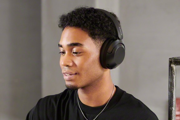Man wearing Sony's WH-XB910N noise-canceling wireless headphones.