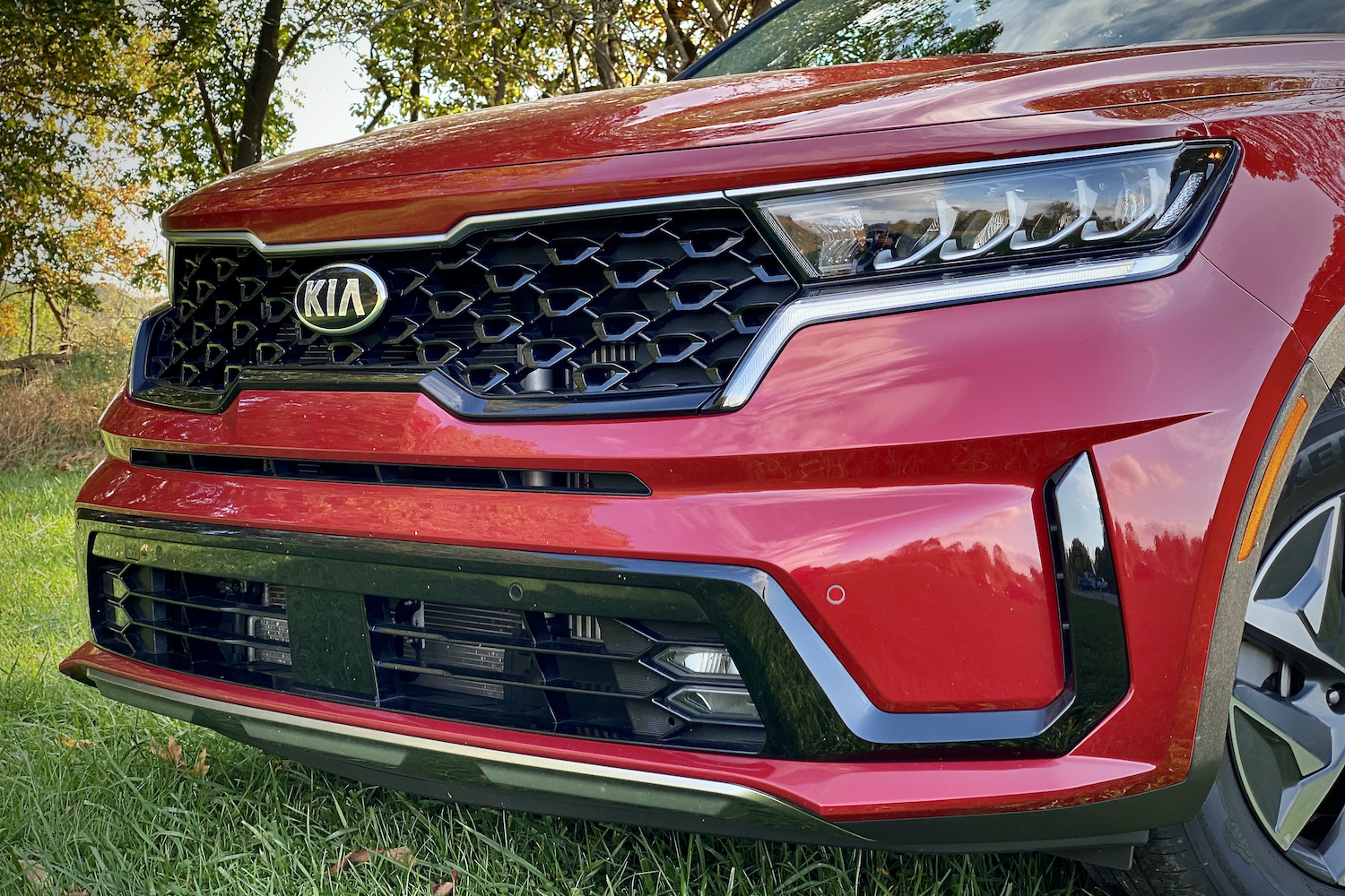 Close up of the front end of the 2021 Kia Sorento Hybrid in a grassy field.