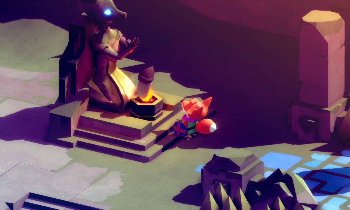 A small fox looks up at a statue in Tunic.