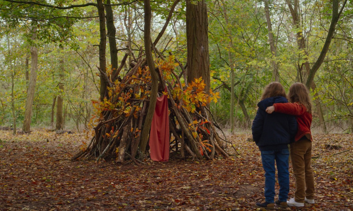 petite maman review nelly and marion look at their fort in