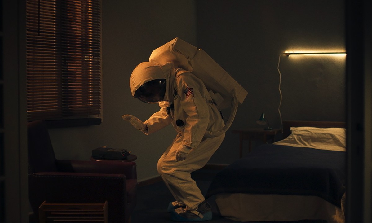 A man in an Astronaut suit dances alone.