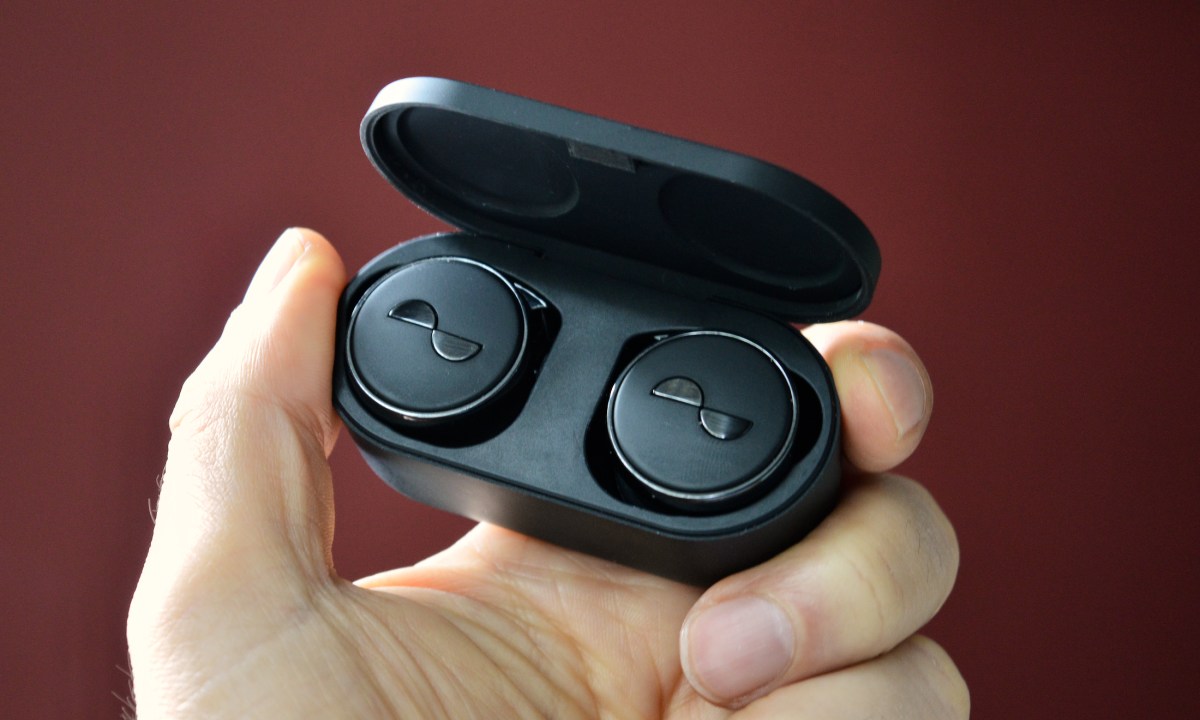 NuraTrue Pro earbuds held in hand.