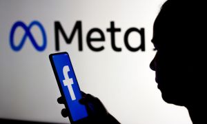 A silhouetted person holds a smartphone displaying the Facebook logo. They are standing in front of a sign showing the Meta logo.