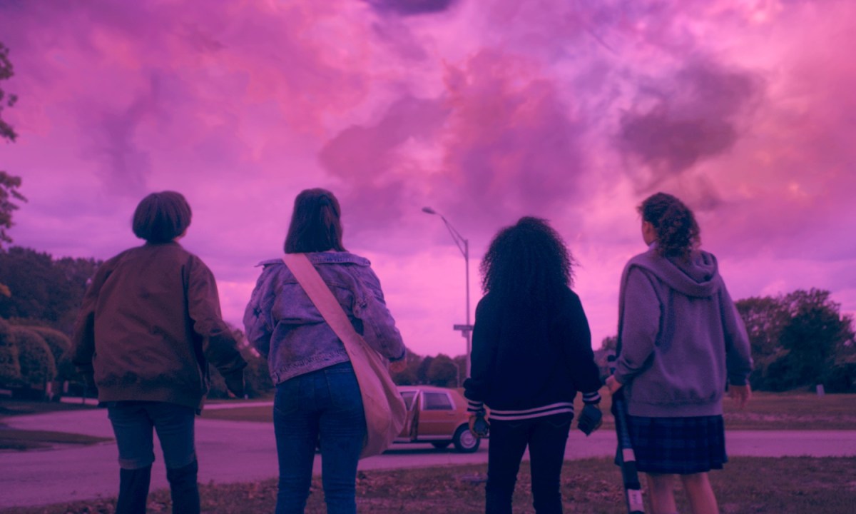 Sofia Rosinsky, Riley Lai Nelet, Camryn Jones, and Fina Strazza look up at a pink sky in a scene from Paper Girls.