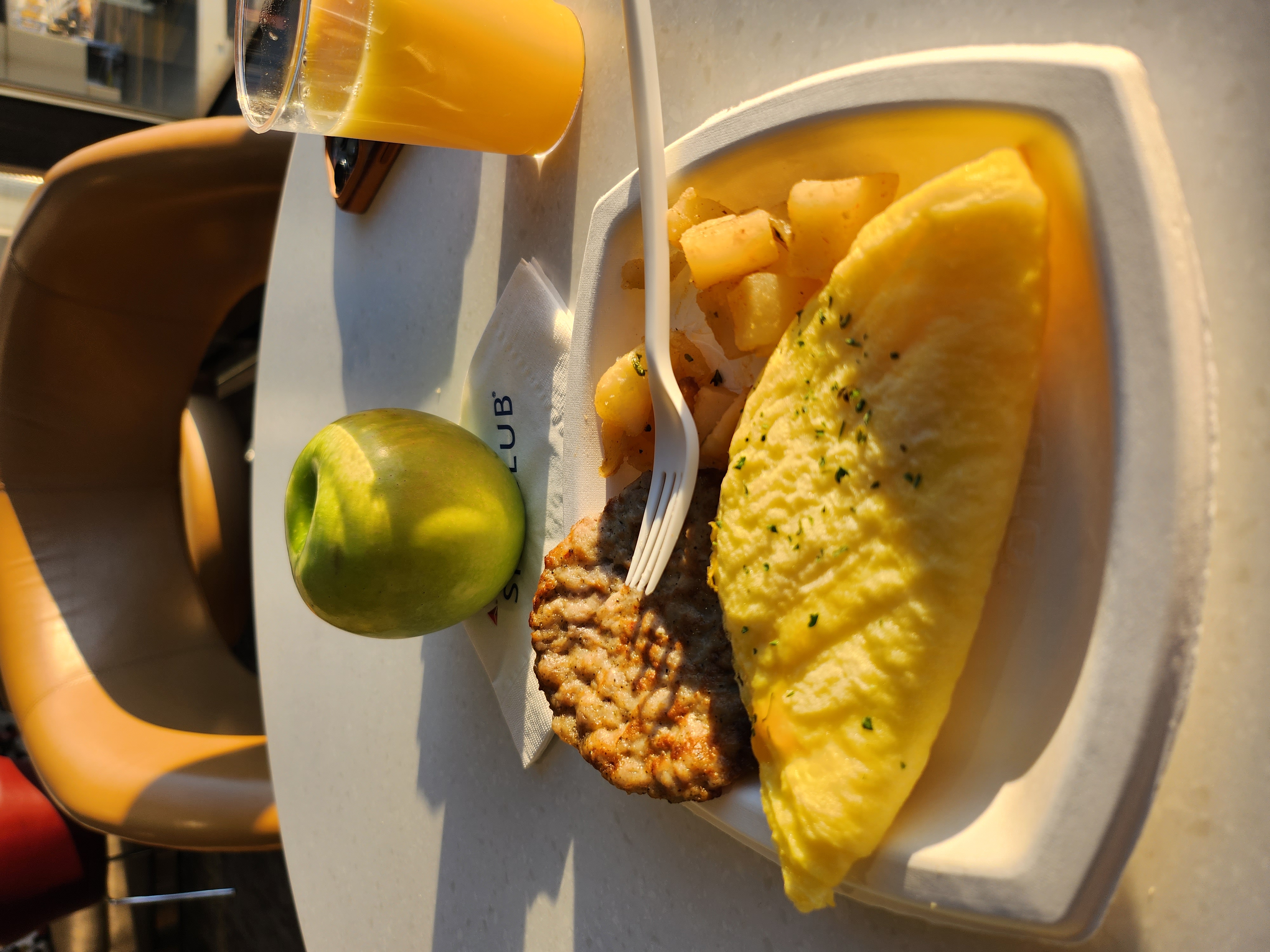 Photo of an omelette and sausage patties on a paper plate.