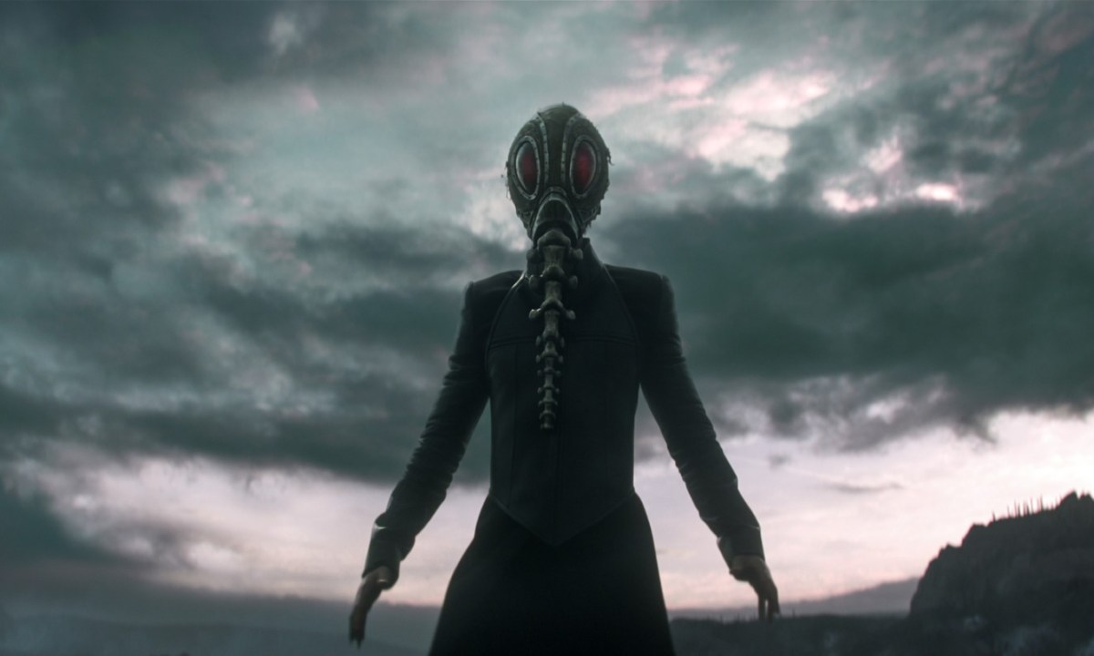 Tom Sturridge wears a mask and cloak as Morpheus in a scene from The Sandman.