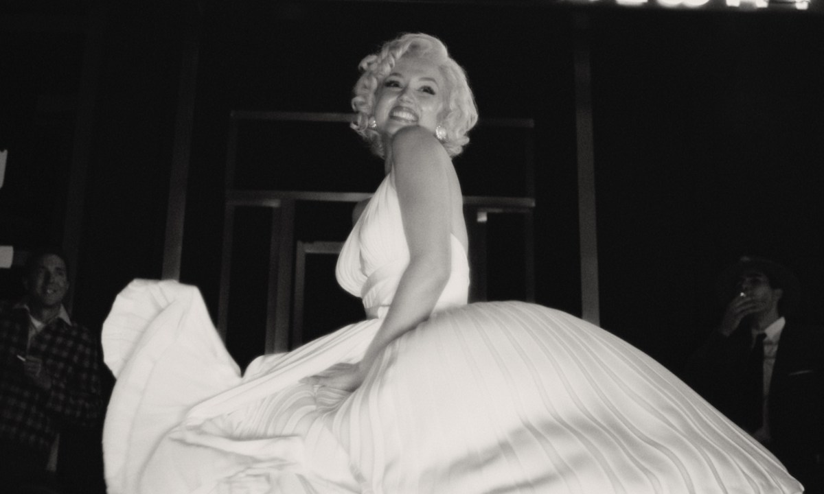 Ana de Armas smiles while wearing a billowing white dress in Blonde.