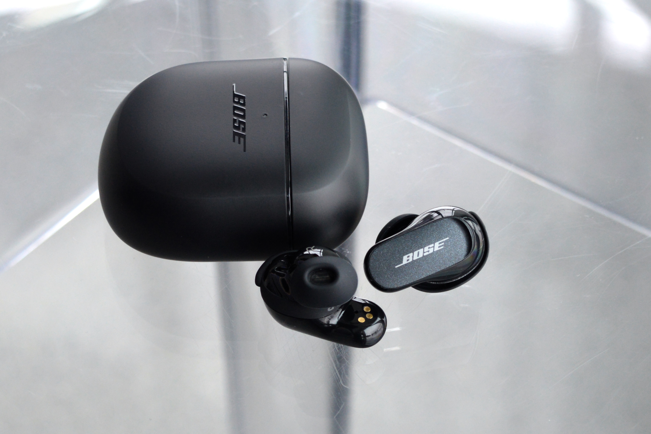 Bose QuietComfort Earbuds II beside charging case.