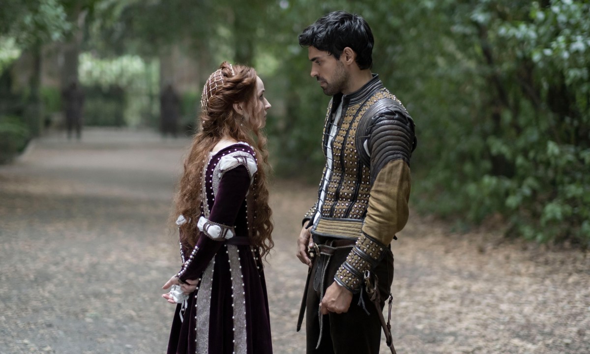 Kaitlyn Dever stands on a forest road with Sean Teale in Hulu's Rosaline.