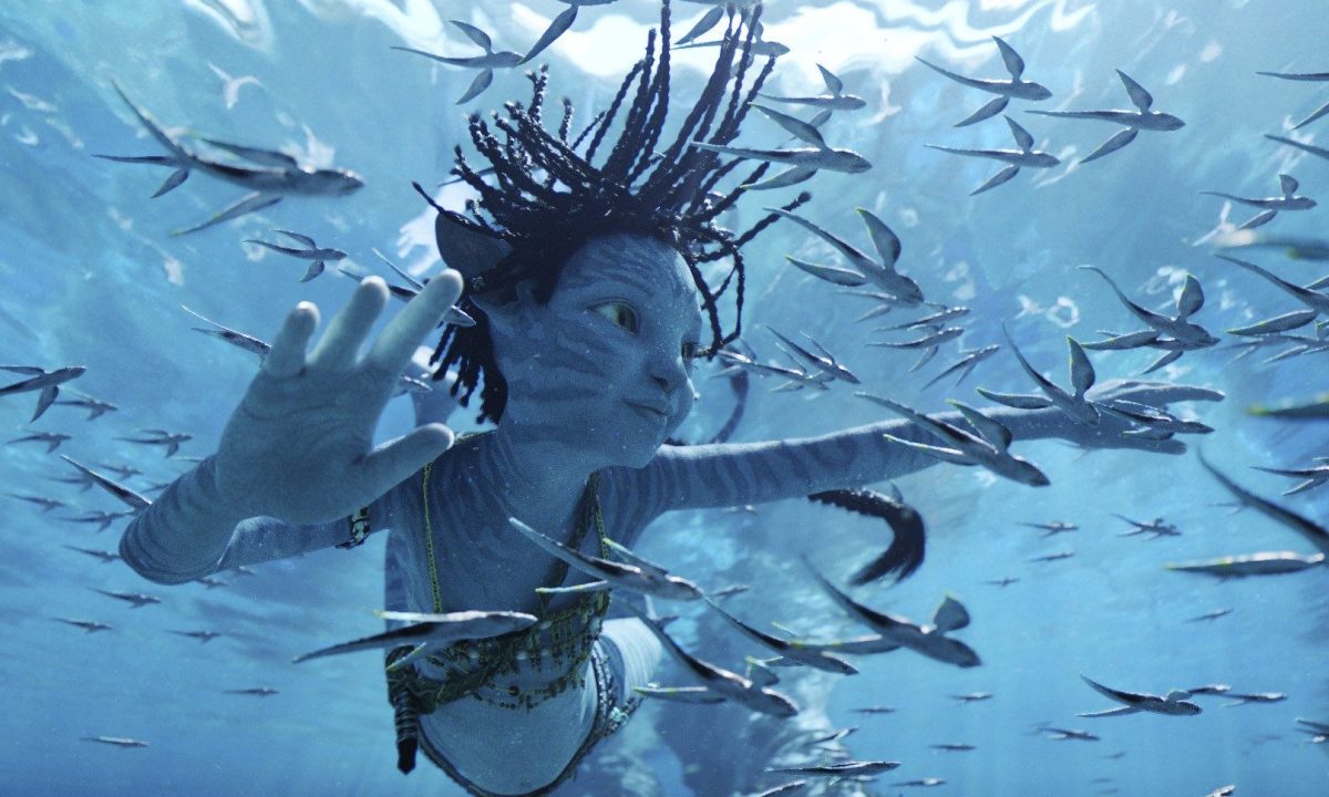 A blue-skinned Na'vi child swims underwater in a scene from Avatar: The Way of Water.