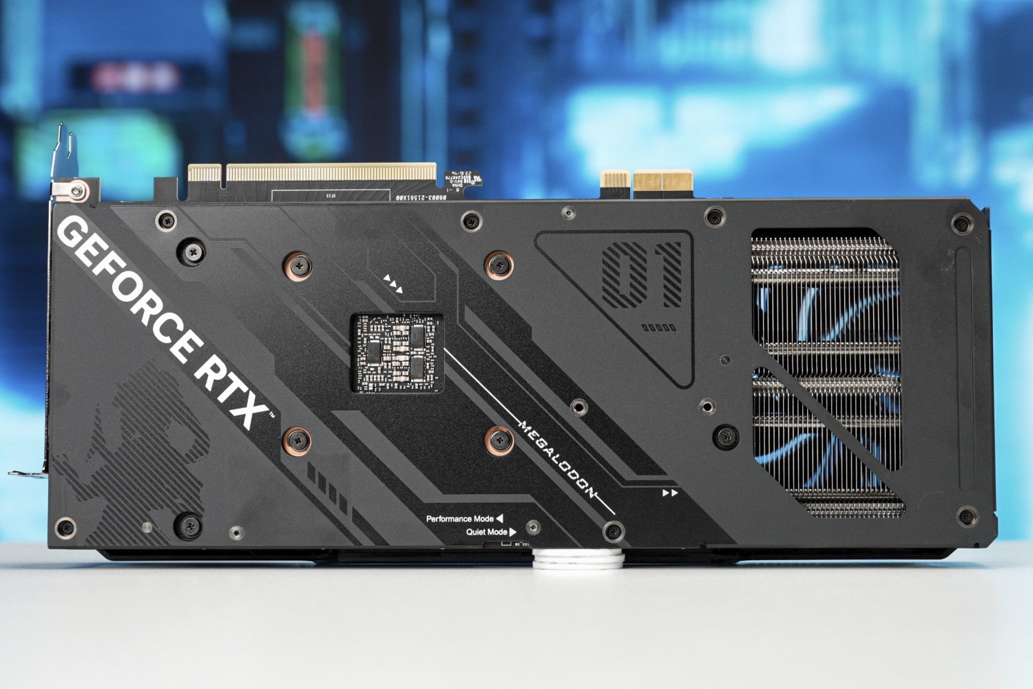 An Asus GeForce RTX 4070 Megalodon graphics card seen from the rear on a table.