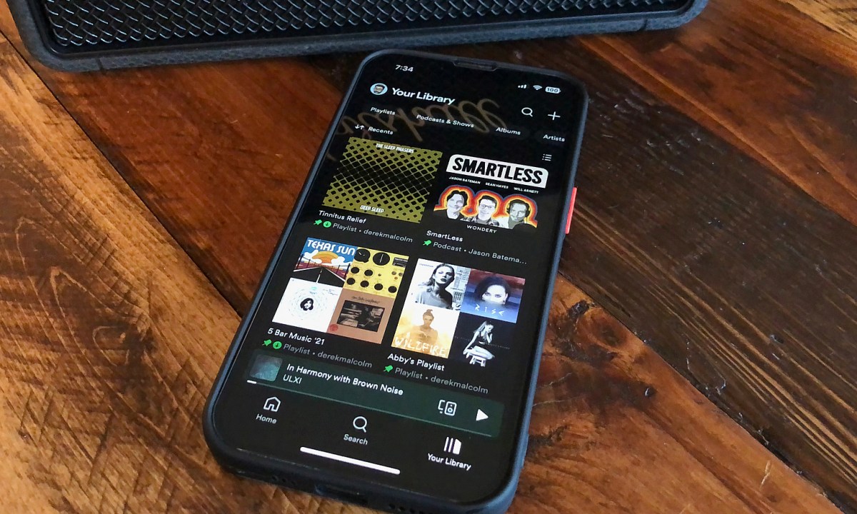 An iPhone with the Home section of the Spotify app on it.