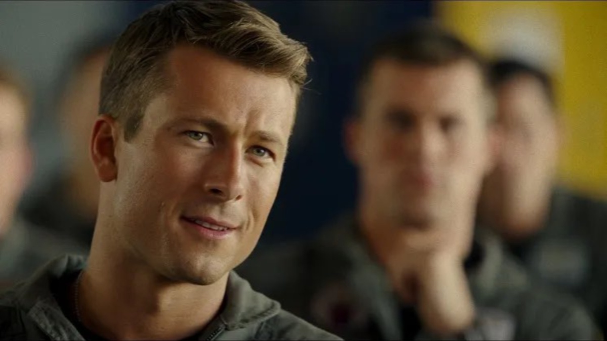 Glen Powell stares and smirks in Top Gun: Maverick.