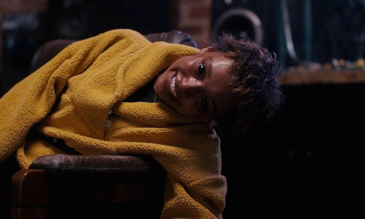 A possessed Sophie Wilde turns sideways with a very spooky grin on her face in "Talk to Me."