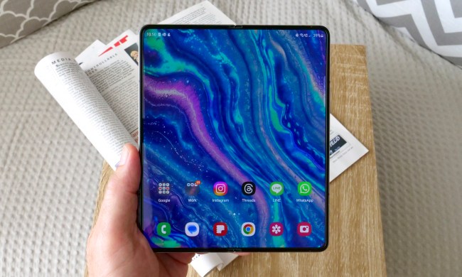 A person holding the open Samsung Galaxy Z Fold 5, showing the screen.