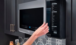 Opening the Samsung 2.1 cu. ft. over-the-range microwave in a kitchen.