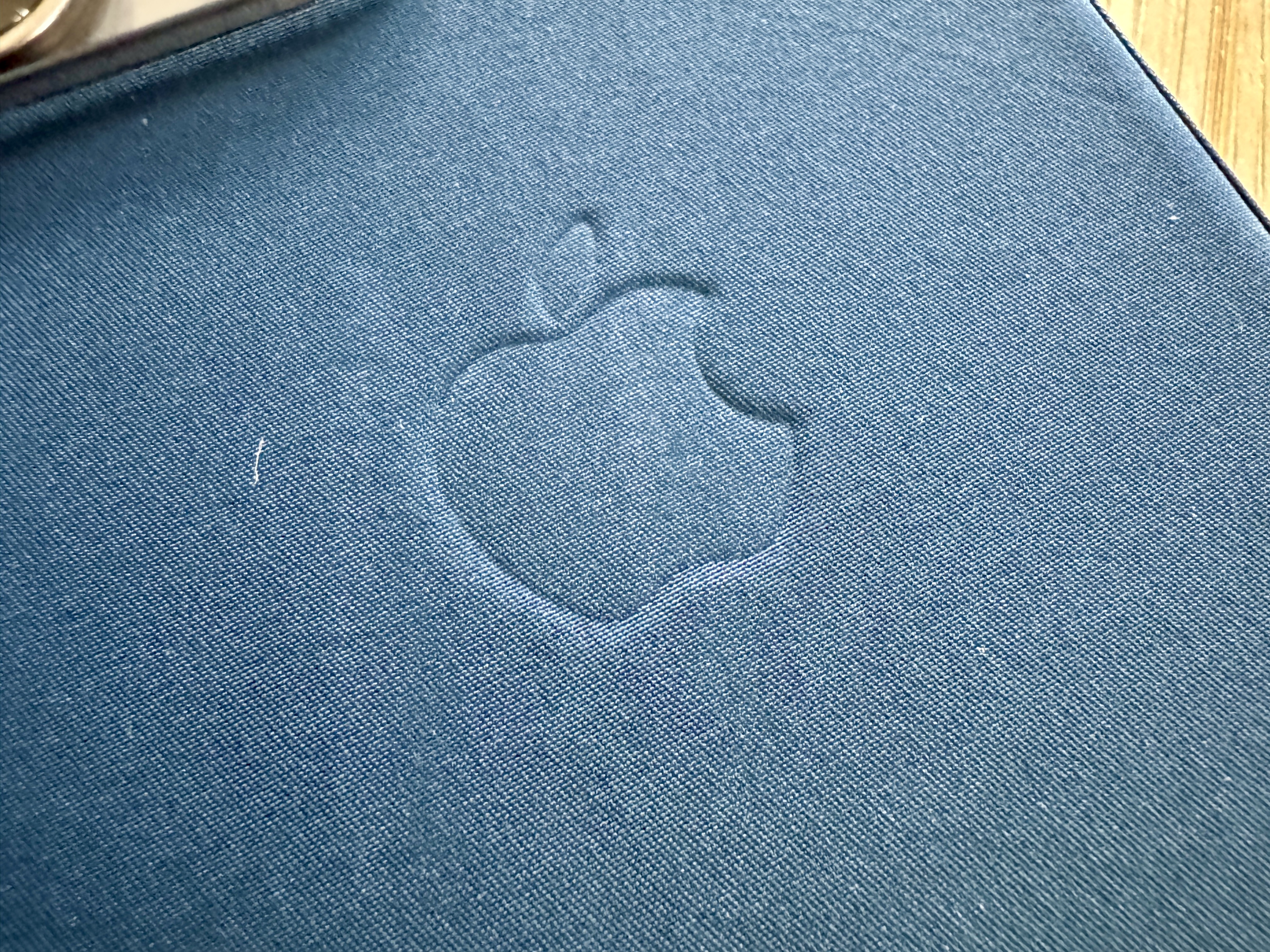 Macro of FineWoven case in Pacific Blue showing scratches and lint.