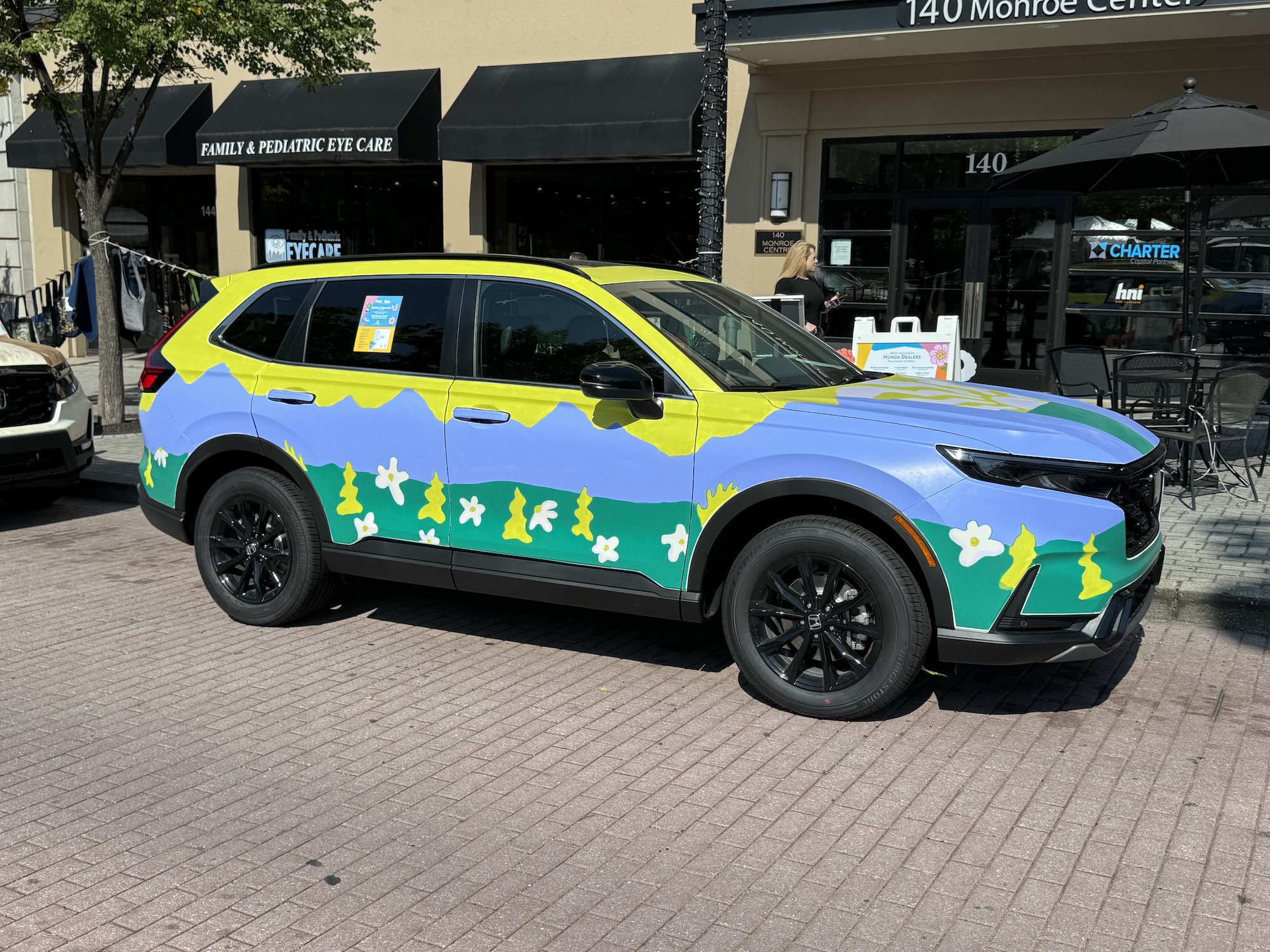 Photo from the iPhone 15 Pro Max main camera of a car painted in yellow, blue, and green.