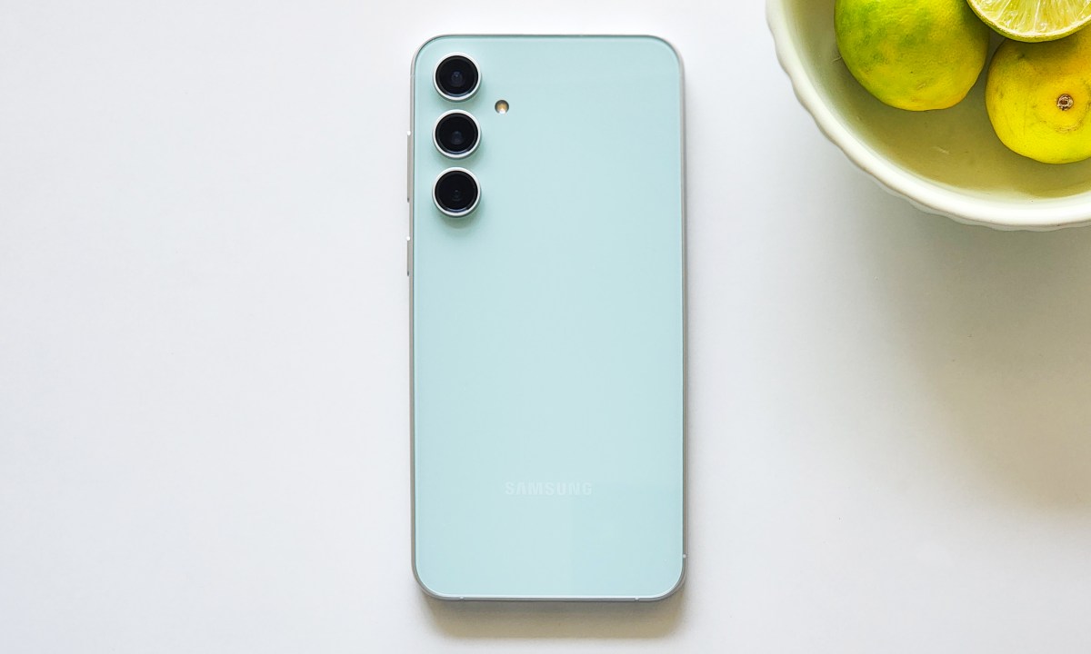 Samsung Galaxy S23 FE Mint Green color along with abowl of lemons.