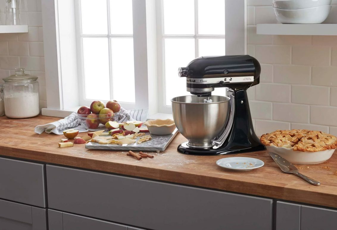 The KitchenAid Classic 4.5-quart stand mixer on a countertop among some baked foods.