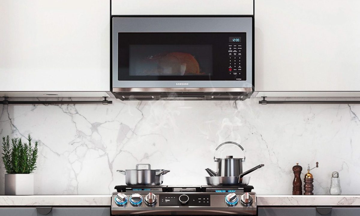 The Samsung 1.7 cu ft. Smart Over-the-Range Microwave mounted in a kitchen.