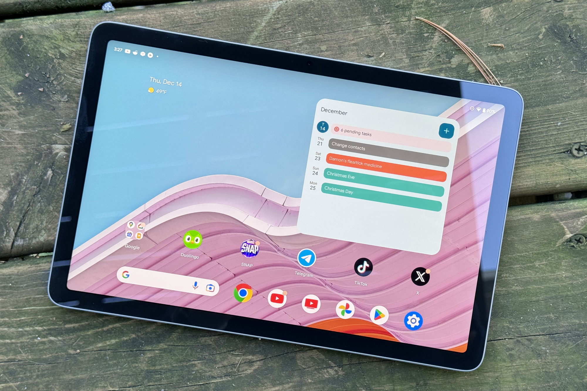 The Google Pixel Tablet sitting outside with its screen on.
