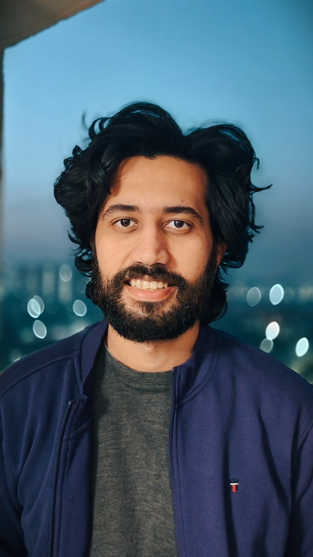 Picture of man wearing purple jacket and gray t-shirt taken with the Vivo X100's Zeiss camera.