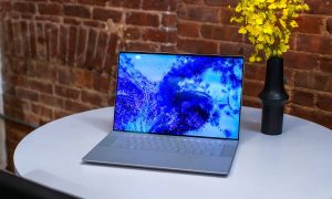 Dell XPS 16 sitting on desktop with flowers.