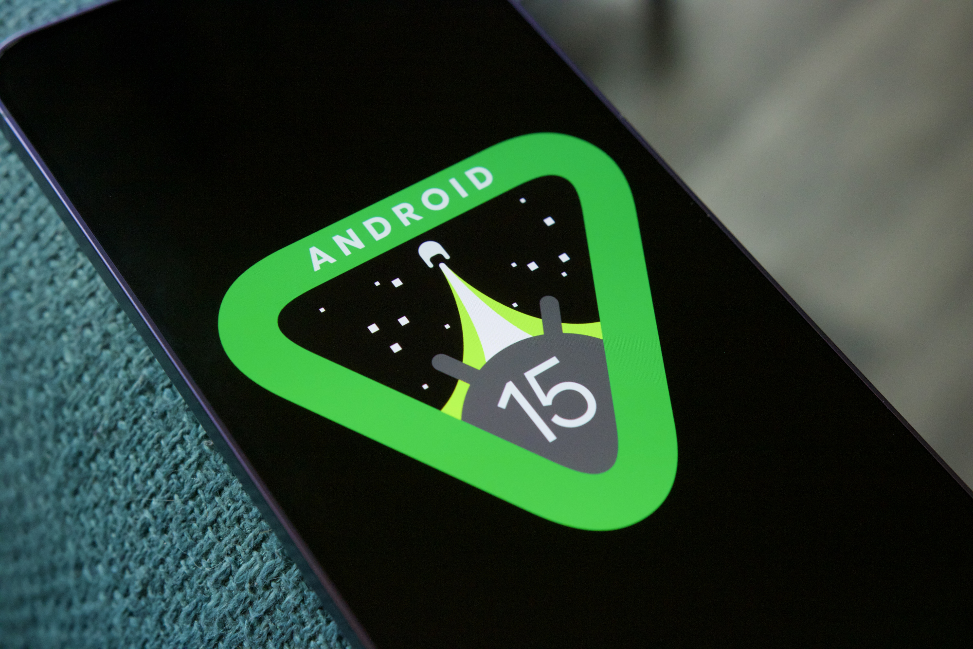 The Android 15 logo on a smartphone.