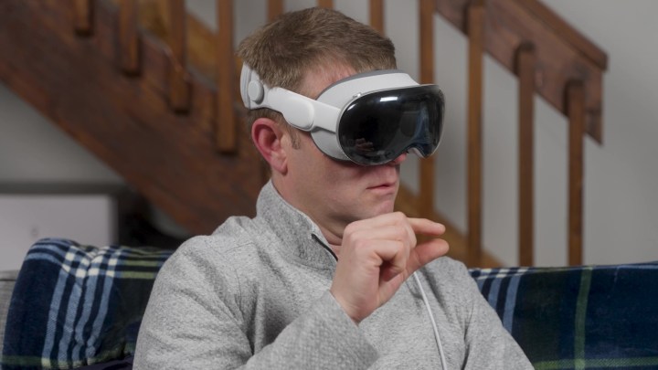 A person pinches while wearing an Apple Vision Pro.