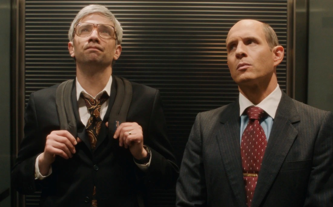 Two men stand in an elevator in BlackBerry.