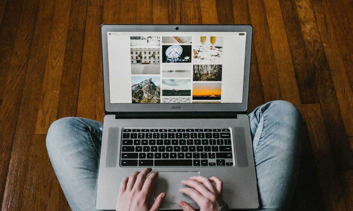 Person using their laptop on the floor.