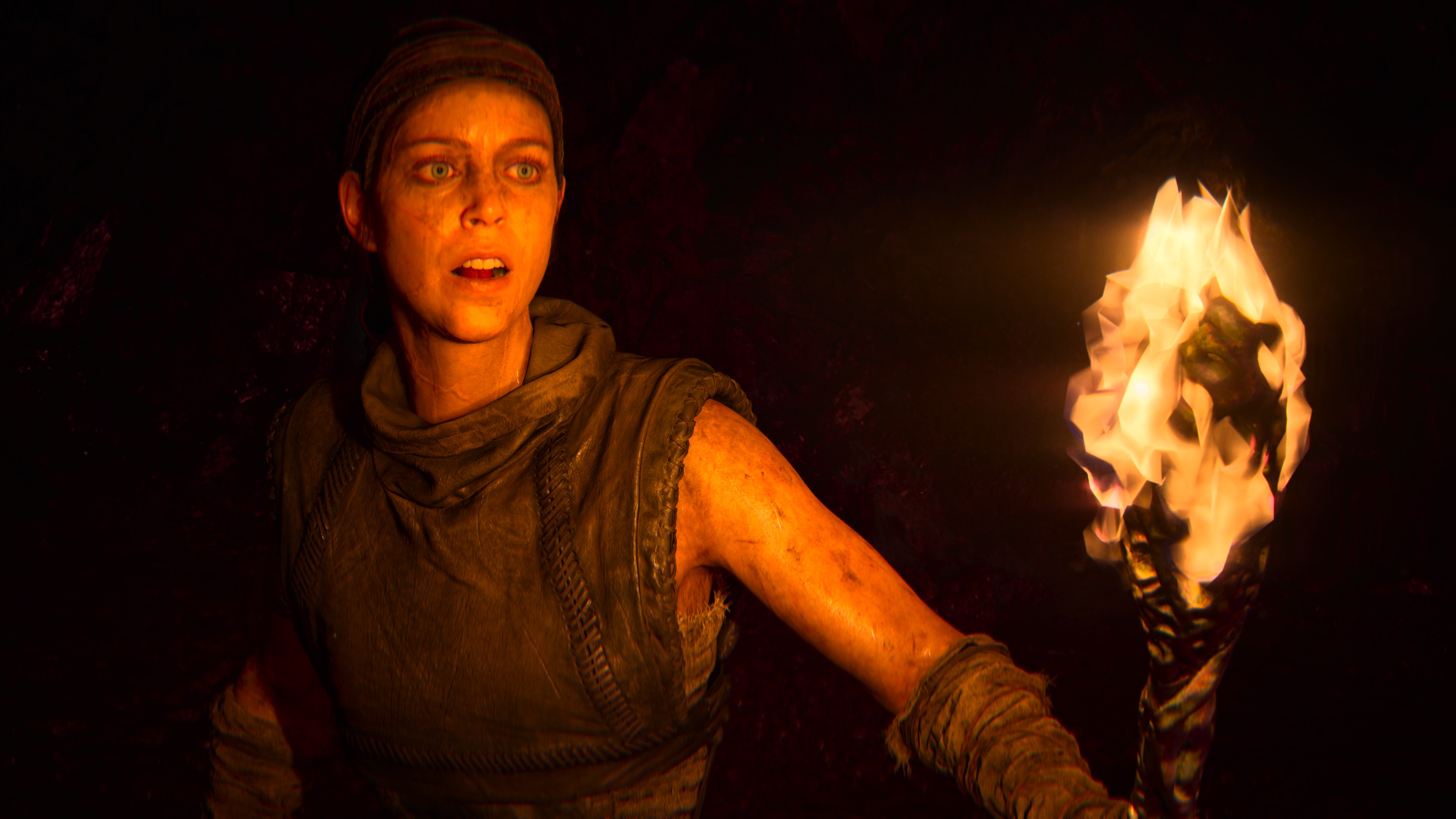 Senua carries a torch in Hellblade: Senua's Sacrifice.