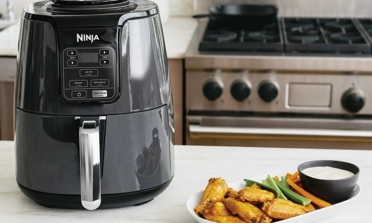 The Ninja 4QT Air Fryer next to a plate of food.