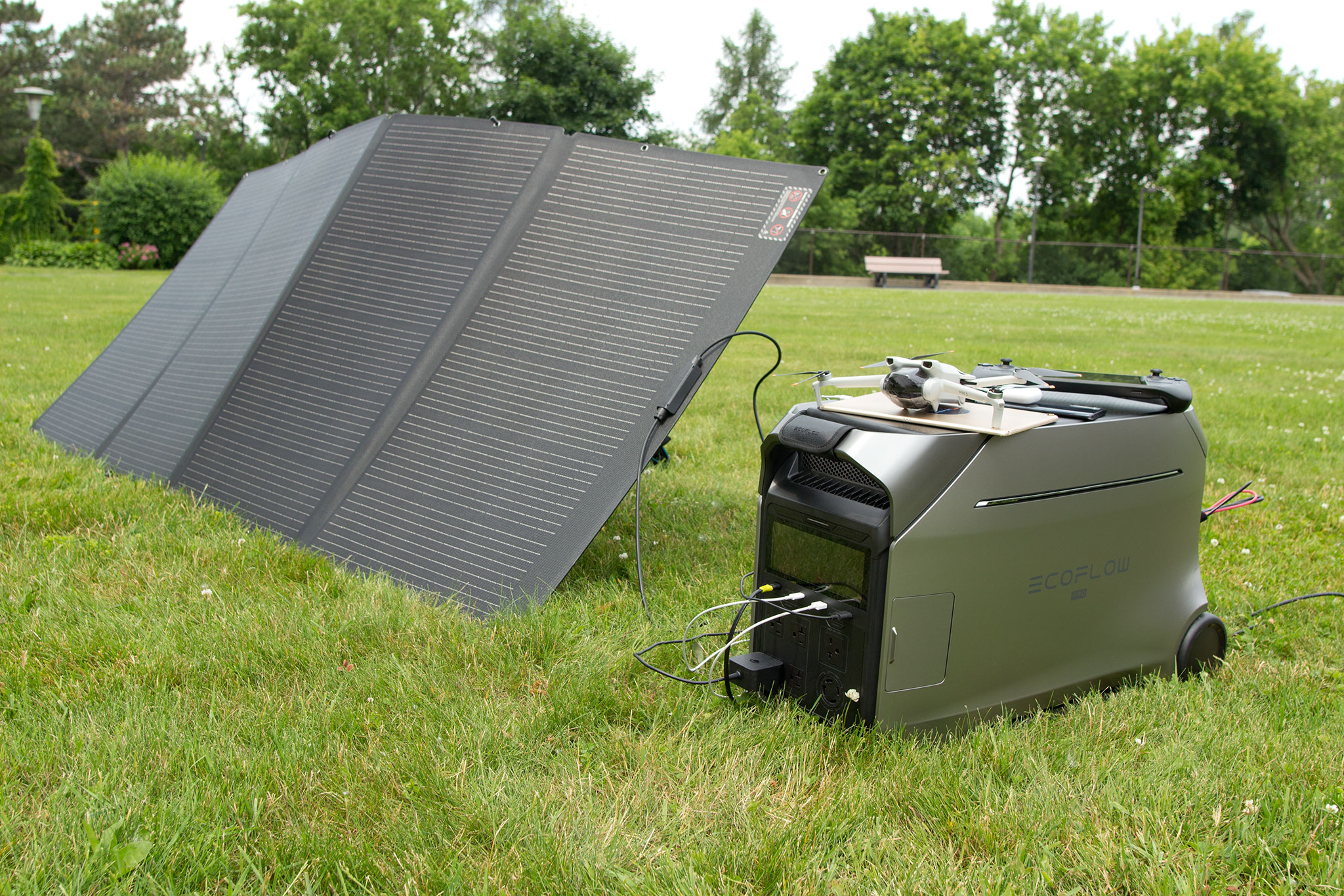 EcoFlow Delta Pro 3 power station on grass, connected to solar panels and several personal devices.