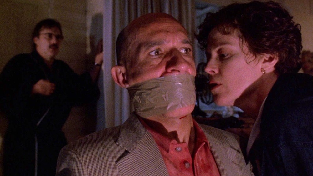 A woman leans near a gagged man in Death and the Maiden.