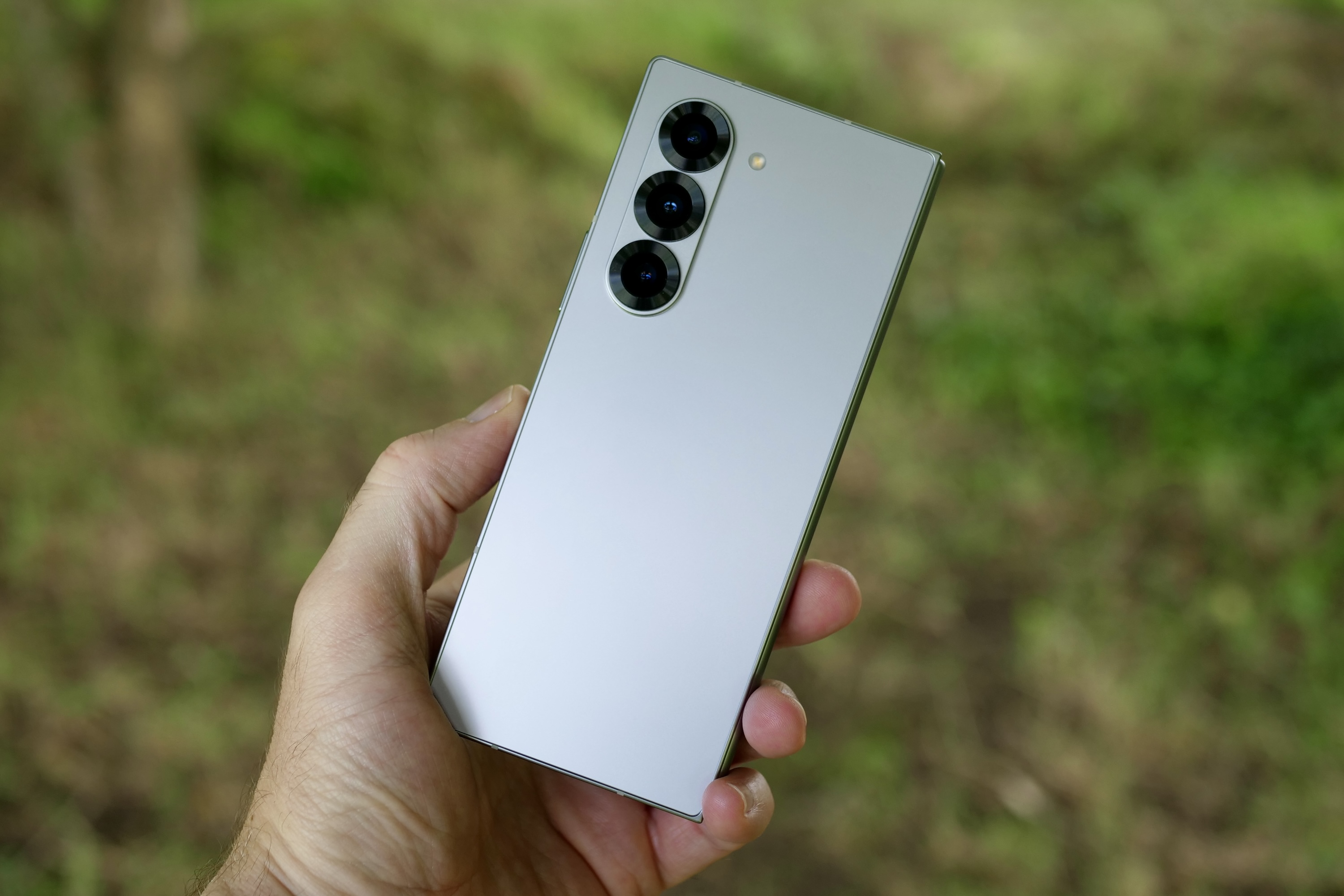 A person holding the Samsung Galaxy Z Fold 6, showing the back of the phone.