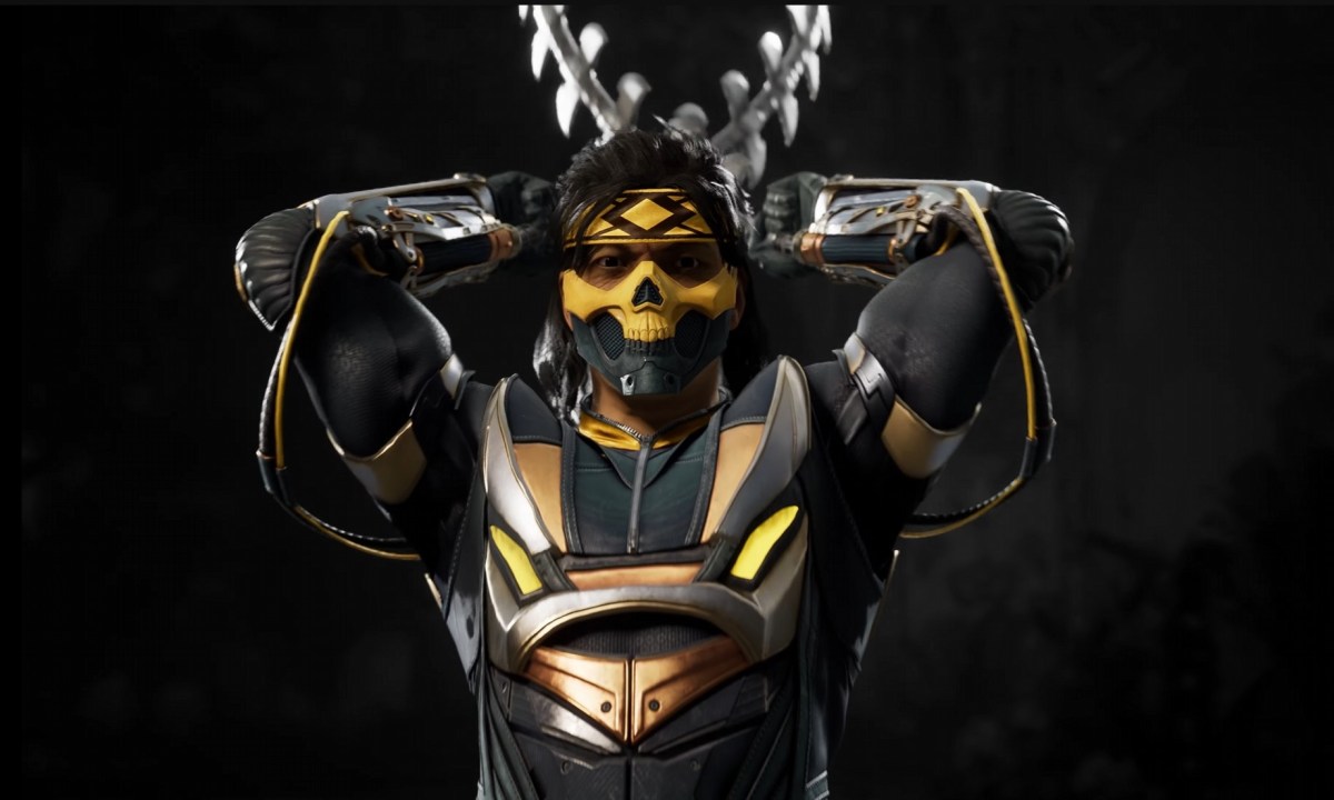 Takeda readying up his chains behind him as he stares into the camera. He's wearing a yellow and black mask and matching armor.