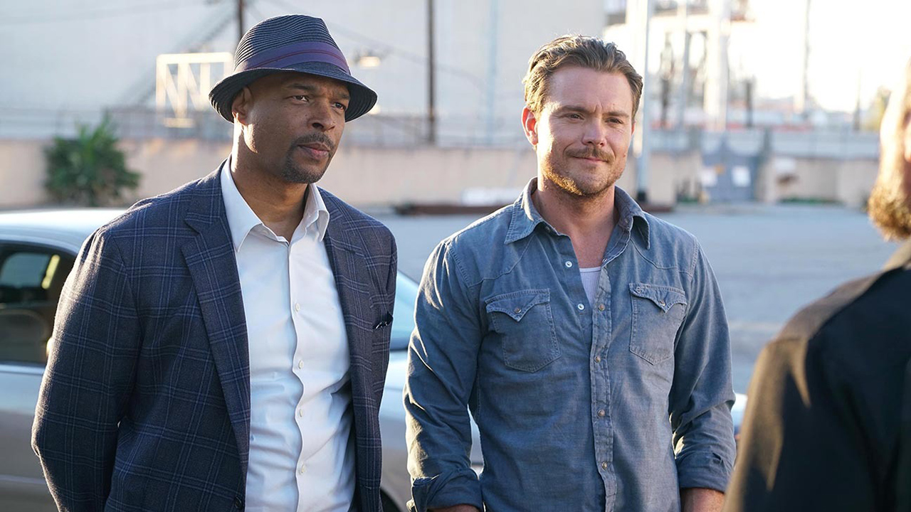 Murtaugh and Riggs standing outside talking to someone in the Lethal Weapon series.