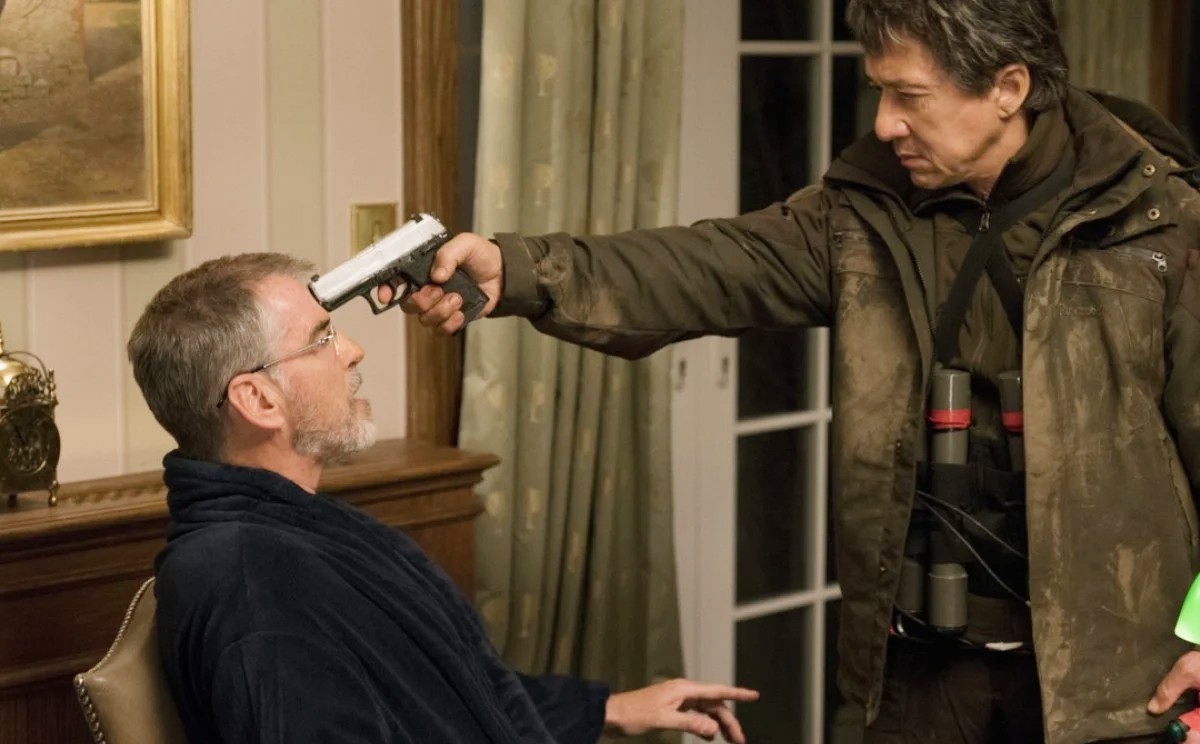 A man aims a gun at another man in The Foreigner.