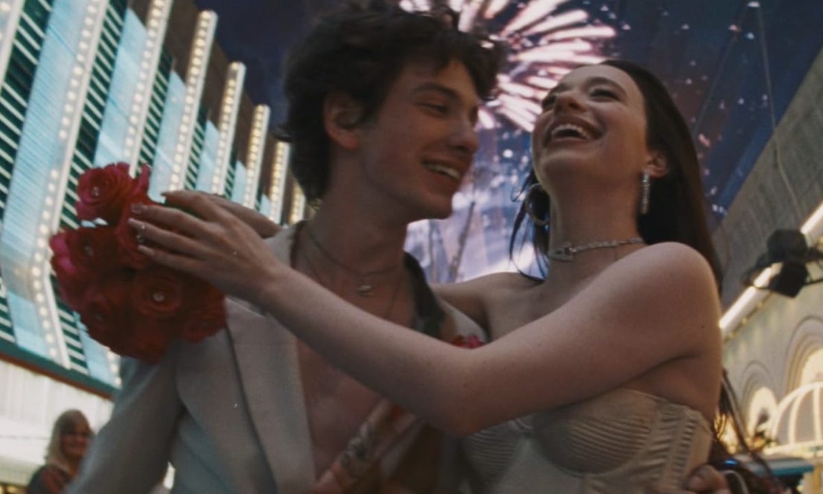 A woman holds onto the shoulders of a man.