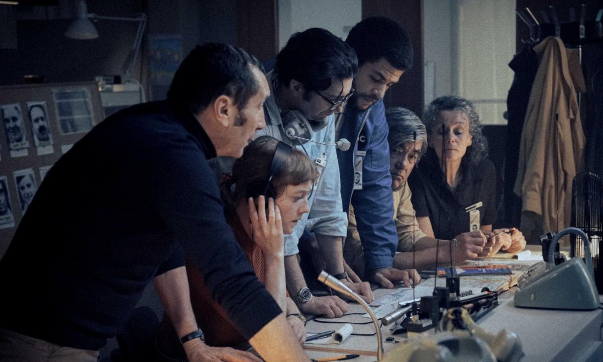 A group of people stand over a sound board in a still from the movie September 5.